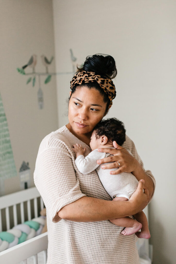 young woman holding baby close to chest