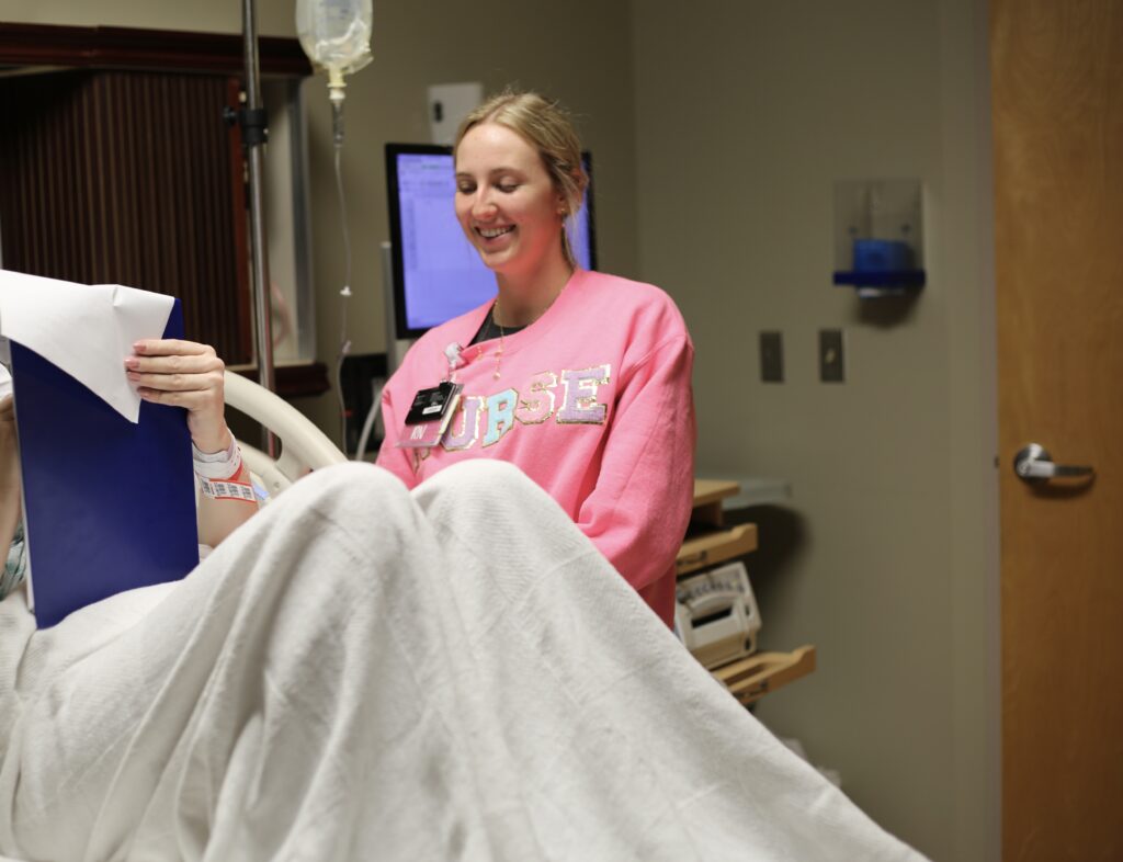 nurse standing by patient as they fill out consent forms